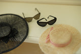 Close-up of a vintage-inspired miniature straw hat for collectible fashion doll