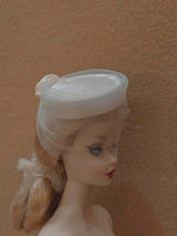 Close-up of the  ribbon and bow on a beige miniature straw hat