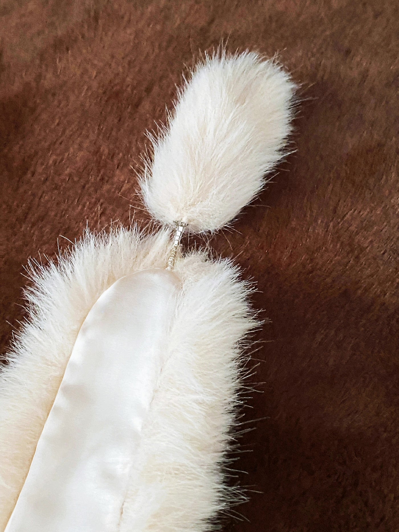 Beige faux fur stole for 1/6 scale dolls shown flat on a brown fur backdrop