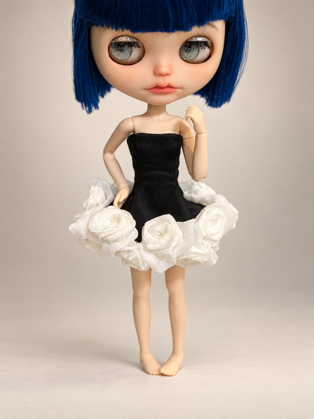 Blythe doll wearing a handmade Black Swan dress with a black strapless bodice and white rose tutu skirt on a luxury studio background