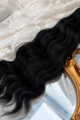 Close-up of black natural mohair doll hair showing fine fibers, waves and silky sheen