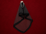 Black lace bridal veil with pearl hair ornament on deep burgundy textured background