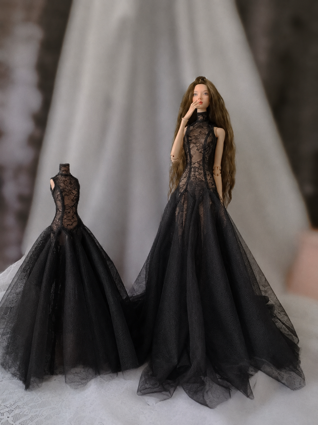 Black floor-length doll dress photographed with dramatic dark styling.