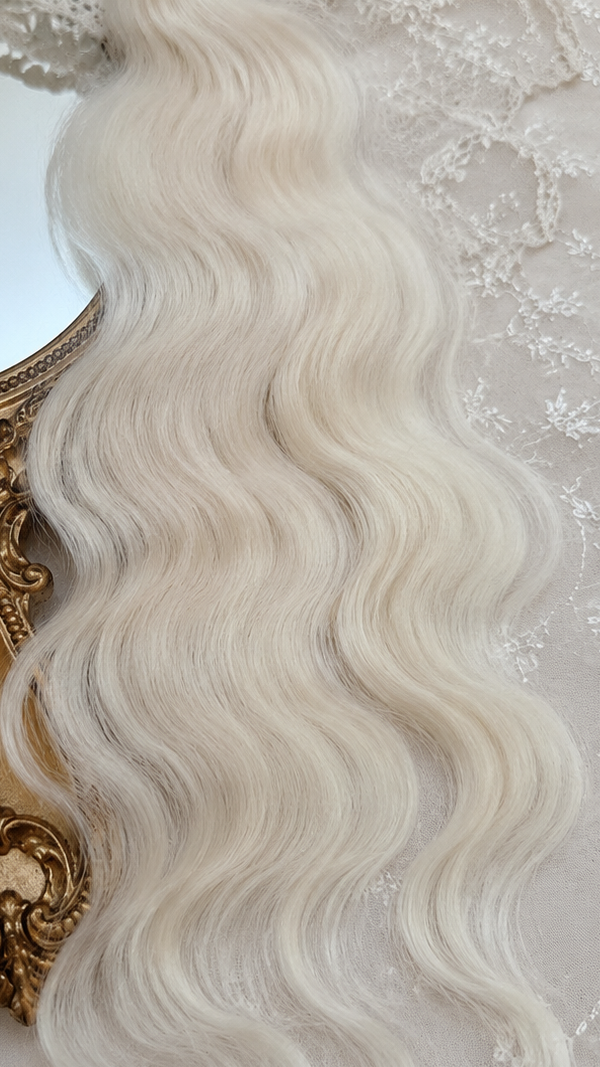 Platinum blonde natural mohair doll hair, full overhead flat lay showing the complete fiber bundle
