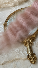 Snow pink natural mohair doll hair, three-quarter view on ivory lace with a gold baroque mirror