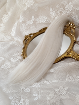 Straight white natural mohair doll hair, three-quarter view on ivory lace with a gold baroque mirror
