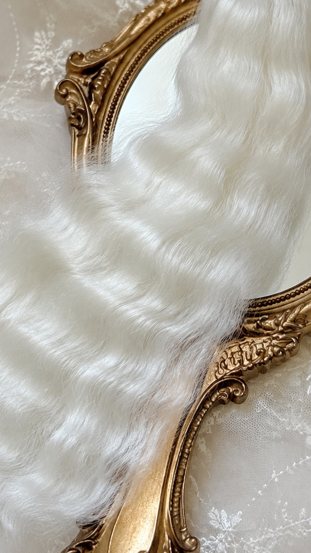 White natural mohair doll hair, three-quarter view on ivory lace with a gold baroque mirror